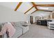 Spacious living room featuring beamed ceilings, a comfortable gray sofa, and seamless access to the updated kitchen at 5775 S Pagosa Way, Centennial, CO 80015