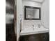 Stylish powder room featuring a black vanity, white sink, framed mirror, and a towel rack, offering a convenient space at 5775 S Pagosa Way, Centennial, CO 80015