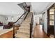 Carpeted staircase with dark wood railing leading to the upper level, connecting to living spaces with hardwood floors at 5775 S Pagosa Way, Centennial, CO 80015