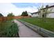 Well-kept backyard with a lawn, sturdy wooden fence, and a walkway leading around the side of the home at 530 S Laredo Cir, Aurora, CO 80017