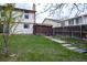Fenced backyard features a lawn, storage shed, and easy access to the home's sliding glass door at 530 S Laredo Cir, Aurora, CO 80017