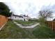 Spacious backyard with mature trees, a lawn, wooden fence, and a swing set at 530 S Laredo Cir, Aurora, CO 80017