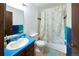 Bathroom featuring a sink with blue countertop, toilet and shower/tub combo with shower curtain at 530 S Laredo Cir, Aurora, CO 80017