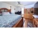 Bedroom featuring a wooden bed frame, hardwood floors, desk, and a ceiling fan at 530 S Laredo Cir, Aurora, CO 80017