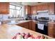 Bright kitchen with wood cabinets, butcher block counters, stainless steel range, and a window view at 530 S Laredo Cir, Aurora, CO 80017
