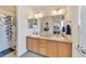 Bathroom with double sinks, wooden cabinets, large mirror, and a shower featuring a stylish blue leaf shower curtain at 726 Vista Verde Hts, Monument, CO 80132