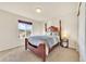 Bedroom featuring a four-poster bed, soft carpet, a side table, and a window with scenic views of the neighborhood at 726 Vista Verde Hts, Monument, CO 80132