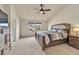 Spacious bedroom featuring a ceiling fan, plush carpet, and a comfortable bed, with natural light from windows at 726 Vista Verde Hts, Monument, CO 80132