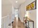 Hallway features hardwood floors, white railings, a console table with flowers, and a modern floral wall decor at 726 Vista Verde Hts, Monument, CO 80132