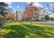 Scenic exterior view of a condominium complex with mature trees, green lawn, and a park bench at 13631 E Marina Dr # 201, Aurora, CO 80014