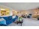 Cozy living room with blue sofa and armchair, view into dining area and kitchen at 13631 E Marina Dr # 201, Aurora, CO 80014