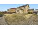 The backyard features grass, rock beds, bushes, a fence, and an exterior view of the home at 10057 Granby St, Commerce City, CO 80022