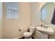 Powder room featuring a pedestal sink, toilet, and a window for natural light at 10057 Granby St, Commerce City, CO 80022