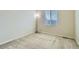 Neutral bedroom featuring carpet floors, base trim, and a large window at 10057 Granby St, Commerce City, CO 80022