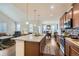 Open kitchen featuring a granite island, stainless appliances, dark wood cabinets, and hardwood floors at 10057 Granby St, Commerce City, CO 80022