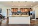 Gourmet kitchen with island, stainless steel appliances, backsplash, pendant lighting, and hardwood floors at 10057 Granby St, Commerce City, CO 80022