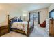 Main bedroom with a decorative bed frame, neutral carpet, and large windows at 10057 Granby St, Commerce City, CO 80022