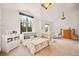Bright bedroom with a crib, twin bed, and a large arched window at 24140 Us Highway 40, Golden, CO 80401