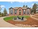 Spacious home with a brick facade, arched entry, fire pit, and manicured front lawn at 24140 Us Highway 40, Golden, CO 80401