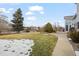 Backyard view with patio, grass, trees, and some snow at 18981 E Belleview Pl, Centennial, CO 80015