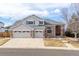 Two-story house with brick and siding, three-car garage, and landscaped yard at 18981 E Belleview Pl, Centennial, CO 80015