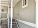Exterior entryway leading up to the front door featuring white railings and light gray siding at 8480 Adams Way, Denver, CO 80229