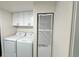 Convenient laundry area featuring side by side washer and dryer, with overhead cabinet storage at 8480 Adams Way, Denver, CO 80229