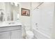 Clean bathroom with a white tub, toilet, gray vanity, and a framed picture of Highland Cows at 13315 Xanthia St, Thornton, CO 80602