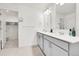 Bright bathroom features a double sink vanity, sleek fixtures, and access to a spacious walk-in closet at 13315 Xanthia St, Thornton, CO 80602
