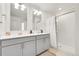 Modern bathroom showcases a double sink vanity, a framed mirror, and a glass enclosed shower with white tile at 13315 Xanthia St, Thornton, CO 80602