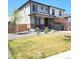 Two-story home with covered porch, lawn, manicured landscaping, and fenced yard at 13315 Xanthia St, Thornton, CO 80602