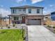 Charming two-story home featuring a brick facade, a well-manicured lawn, and an attached two-car garage at 13315 Xanthia St, Thornton, CO 80602
