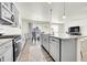 Open-concept kitchen with stainless steel appliances, granite countertops, and hardwood floors at 13315 Xanthia St, Thornton, CO 80602