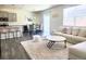 Open-concept living room with a plush rug, stylish furniture, and plenty of natural light at 13315 Xanthia St, Thornton, CO 80602