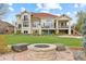 Spacious backyard with stone fire pit, lush lawn, and views of the upper balconies at 16 Blue Heron Dr, Thornton, CO 80241