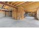 Unfinished basement space with exposed wood beams and concrete floor allows for customization and ample storage at 16 Blue Heron Dr, Thornton, CO 80241