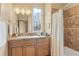 Bathroom featuring tiled shower/tub combo, updated vanity, mirror and vanity lighting at 16 Blue Heron Dr, Thornton, CO 80241