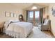 Bedroom with vaulted ceiling, light gray arm chair, and french doors to a balcony at 16 Blue Heron Dr, Thornton, CO 80241