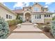 Elegant home entrance featuring a stylish front door, manicured landscaping, and a welcoming walkway with stone benches at 16 Blue Heron Dr, Thornton, CO 80241