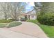 Picturesque front exterior showcasing a circular driveway, mature trees, and beautifully landscaped yard at 16 Blue Heron Dr, Thornton, CO 80241