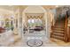 Elegant living room featuring arched doorways, large windows with decorative draperies, and a staircase at 16 Blue Heron Dr, Thornton, CO 80241