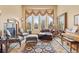 Cozy living room showcasing a large window with curtains, comfortable seating, and a decorative rug at 16 Blue Heron Dr, Thornton, CO 80241