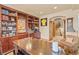 Home office with custom built-in shelving, a large desk, and a view of the staircase at 16 Blue Heron Dr, Thornton, CO 80241