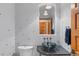 Stylish powder room with a vessel sink, decorative mirror, and unique lighting fixtures at 16 Blue Heron Dr, Thornton, CO 80241