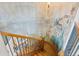 Detailed staircase features a custom mural, wooden railings, and carpeted stairs at 16 Blue Heron Dr, Thornton, CO 80241