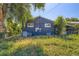 This is a view of a back yard with blue siding, a grill, and overgrown vegetation at 695 S Quitman St, Denver, CO 80219