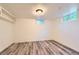Finished basement area with wood-look floors, recessed lighting and small windows at 695 S Quitman St, Denver, CO 80219