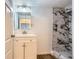 Bathroom with white vanity, modern lighting and black and white tiled shower with glass door at 695 S Quitman St, Denver, CO 80219