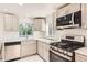 Bright kitchen featuring stainless steel appliances, subway tile, gray cabinets, and white countertops at 695 S Quitman St, Denver, CO 80219