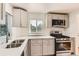Well-lit kitchen with gray cabinets, stainless steel appliances, and a subway tile backsplash at 695 S Quitman St, Denver, CO 80219
